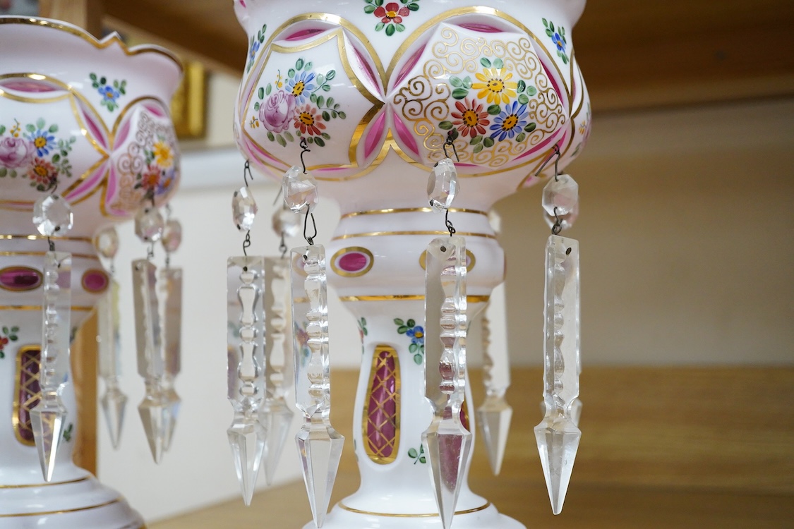 A pair of Bohemian/Czech overlaid glass table lustres raised on octagonal pierced metal bases, 31cm high